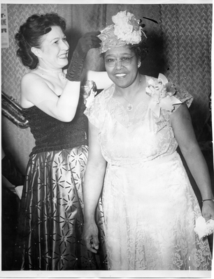 Loudella Lyons placing hat on unidentified woman