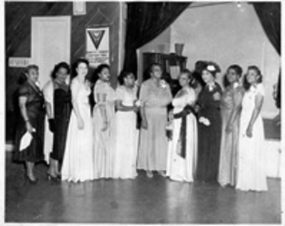 Group photograph of women standing next to stage