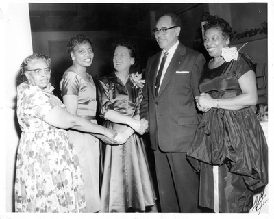 Four women shaking hands with William Byron Rumford