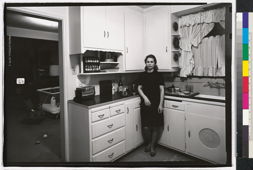[Gertrude Hare standing in kitchen, Kensington, California.]