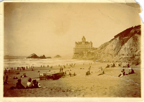 [People congregating on Ocean Beach across from the Cliff House]