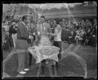 Golfer Walter Hagen, Max Turner and Helen Robinson cutting cake at the 4th annual Pasadena Open tournament, Pasadena, 1931-1932