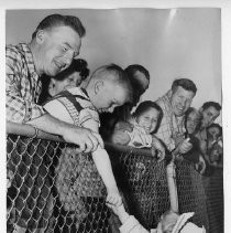 Young girl, April Eaton, granddaughter of Gov. Goodwin Knight shakes hands with spectators at the airport. She is the daughter of Mrs. Robert Eaton, who is the daughter of the governor