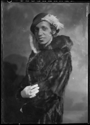 Portrait of woman in a fur coat and feathered hat