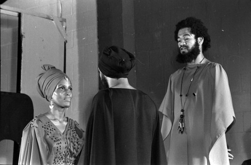 Horace Tapscott looking down at a man and a woman