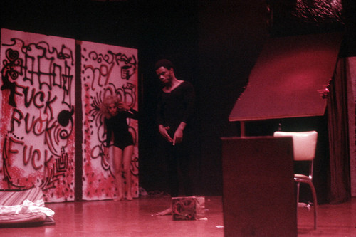 Performance with a man standing center stage and a woman in the background