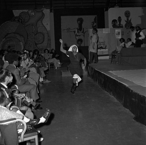 Woman moving and performing in front of a stage