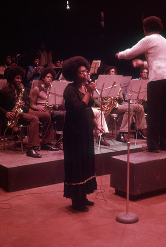 Ruth Emerson standing next to Troy Robinson singing with CAA orchestra in background