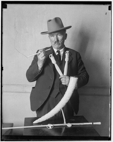 Portrait of unidentified collector holding artifacts