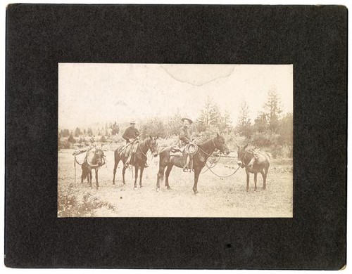 Armed cowboys on horseback