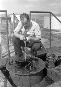 Man checking the oil level in an oil storage tank