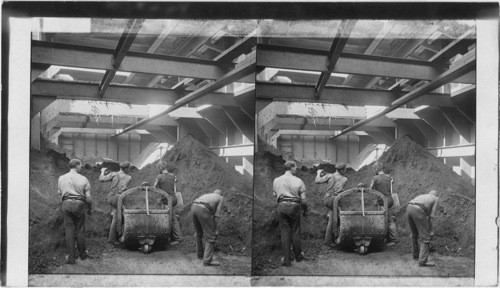 Unloading one-ton in hold of ore-carrying steamer, Cleveland, Ohio