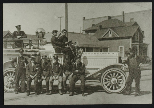 Nine unidentified personnel sitting on a fire truck