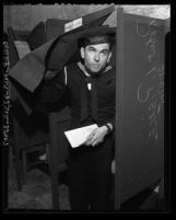 Navy serviceman Robert L. Pierce exiting voting both after casting his absentee ballot, Los Angeles, Calif., 1945