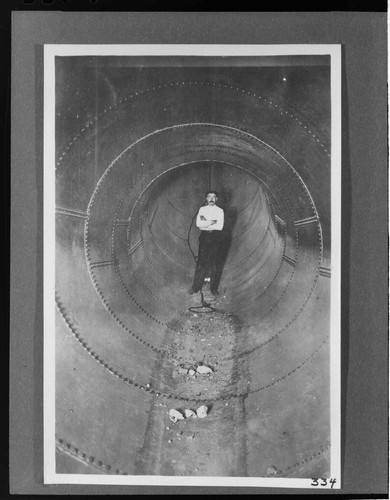 A man standing inside the completed section of penstock at the Kern River #1 Hydro Plant