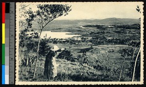Missionary father on a hilltop gesturing toward a village, Madagascar, ca.1920-1940