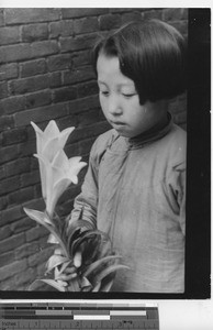 A girl with Easter lillies at Fushun, China, 1940