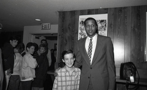 Jamaal Wilkes posing a young boy at a special event, Los Angeles, 1988