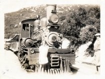 A girl and man standing beside Mt. Tam & Muir Woods locomotive, circa 1925