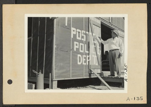 Poston, Ariz.--Police Chief Kiyoshi Shigekawa painting sign on first police station at this War Relocation Authority center for evacuees of Japanese ancestry. Photographer: Clark, Fred Poston, Arizona