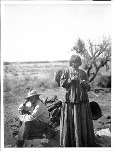 Apache Indian man and woman at their camp, 1903