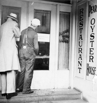 [Two men standing at the entrance to the Pearl Oyster House]