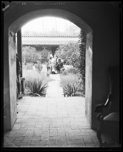 Mexican couple seated on a fountain as viewed through a breezeway