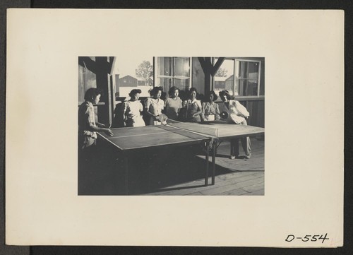 Manzanar, Calif.--These girls are enjoying a game of ping-pong in the girls' recreation center at this War Relocation Authority center for evacuees of Japanese ancestry. Photographer: Stewart, Francis Manzanar, California