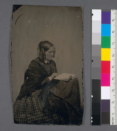[Mrs. George Ansel Sterling seated and reading a book.]