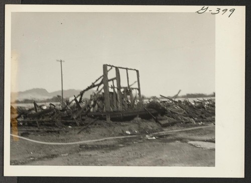Shown here are the remains of the six barracks after the fire on Christmas night, 1943, which swept block 202, Poston No. II. Poston, Arizona