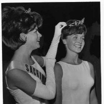 SUCCEEDS TO THRONE - Cappie Gshwandtner, 18, right, or Folsom, last night was crowned Miss Metropolitan Sacramento for 1965 by last year's winner, Betty Lu Mathis