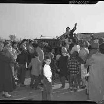 A crowd of people looking at Santa Claus on a fire truck