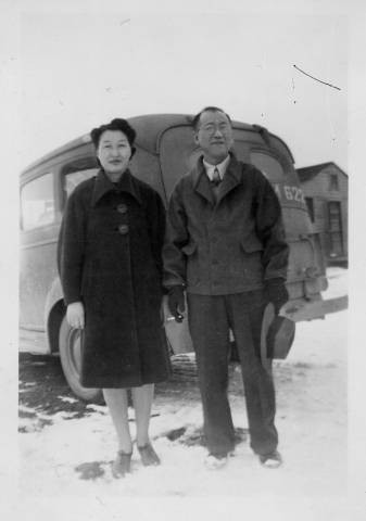 Dr. Taro Akamatsu and wife, Yasuka Akamatsu, standing at rear of ambulance at Tule Lake Relocation Center