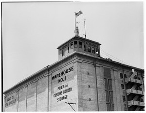 Exterior view of a warehouse with the Marine Exchange building on the roof