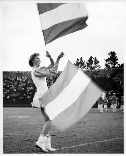 Action Shot of a Female San Jose State College Color Guard Spinning Her Flags