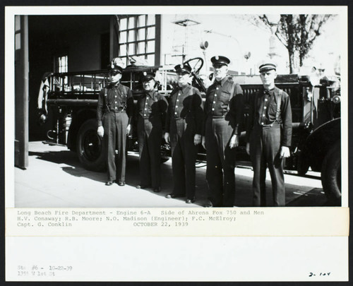 Personnel stand front of an Ahrens-Fox 750 at Station No. 6, 1355 W. 1st St