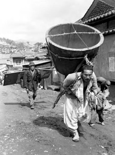 Laborer carrying large pot