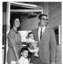 Mr. and Mrs. Eugene Gualco in front of campaign HQ, with their children