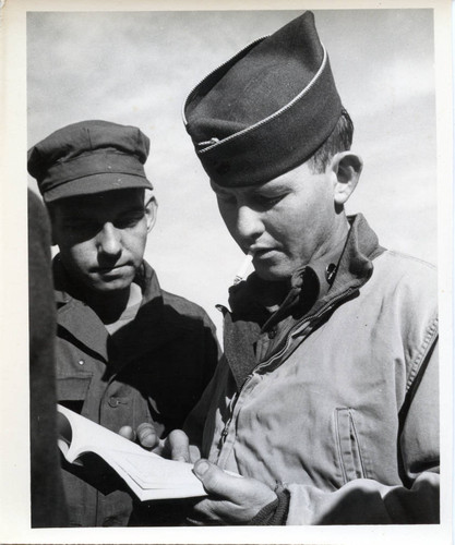 Two servicemen with book at Fort Ord