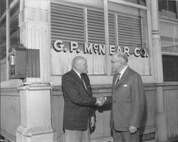 E. Denman McNear with an unidentified man in front of the G.P. McNear Company office, Petaluma, California, 1959