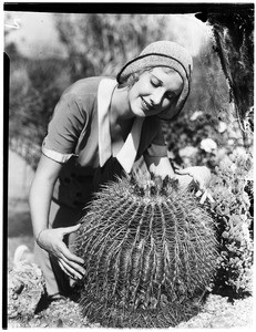 Woman standing behind a barrel cactus