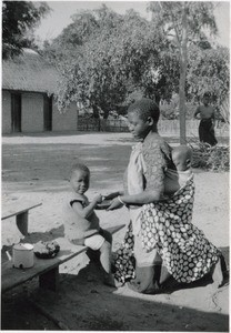At mealtime. Daion and her elder sister Libowa who is carrying her son on her back