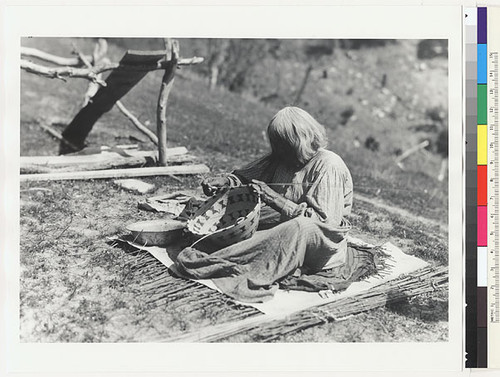 Woman making a coiled basket; dishpan contains water for moistening materials