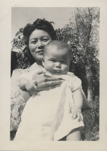 Woman holds a baby at Poston incarceration camp