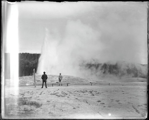 Two men watching a geyser, Yellowstone National Park. [negative]