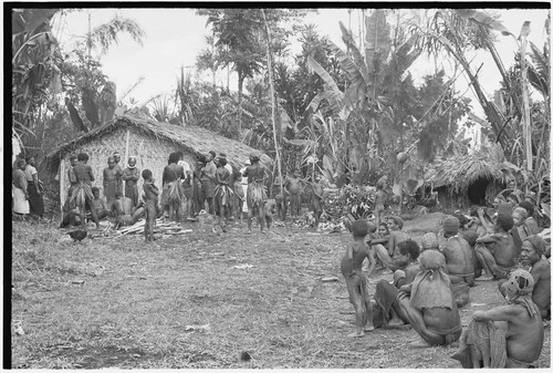 Returned laborers, purification ritual: in front of house built by returned laborers, preparations for sacrifical feast are made