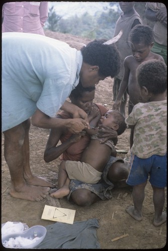 Maternal and child health clinic: health care worker gives an injection to a young child