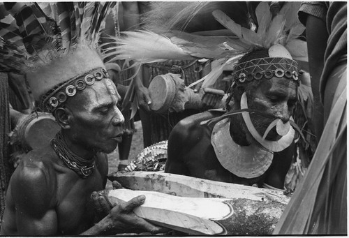 Pig festival, pig sacrifice preparations: Kolip and Kent blow spells on gate posts for ritual fence through which allies will be fed