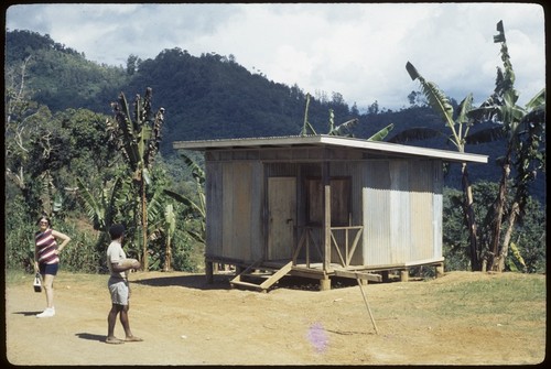 Susan Pflanz-Cook and a man outside Kavali's trade store, Tabibuga