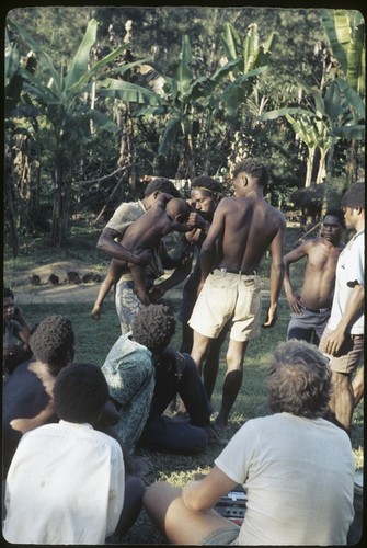 Local court case, child being pulled by men during a dispute over child's place between two groups